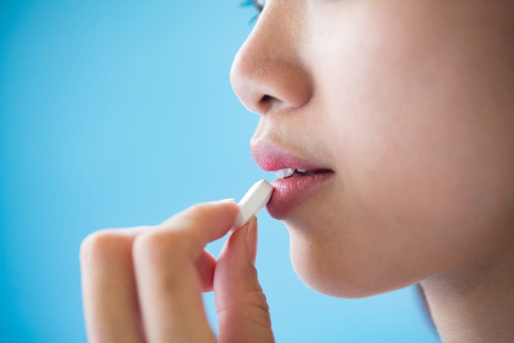 young woman taking medicine pill after doctor order